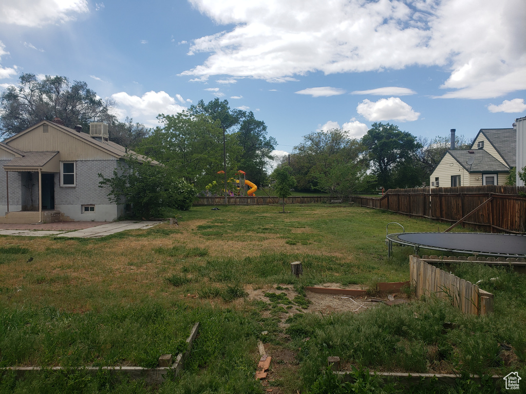 View of yard with a playground, a patio area, central air condition unit, and a trampoline