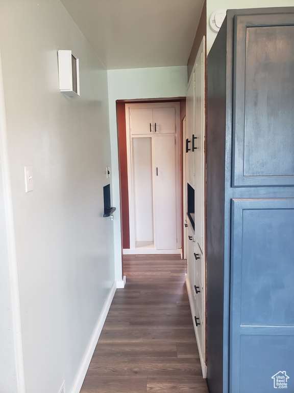Hallway featuring baseboards and dark wood-style flooring