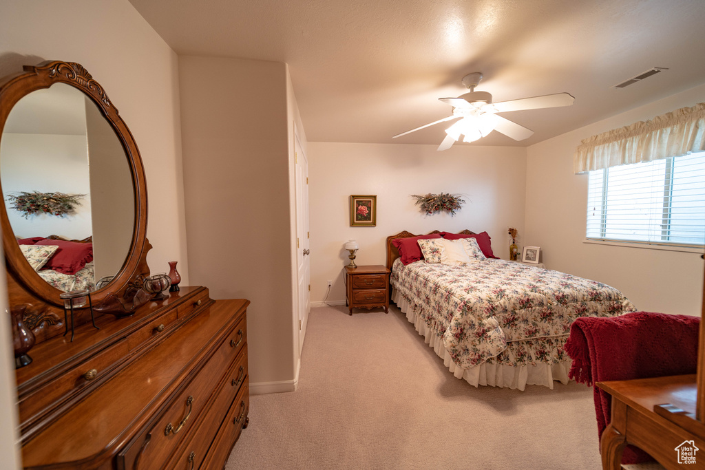 Bedroom with light carpet, baseboards, and ceiling fan