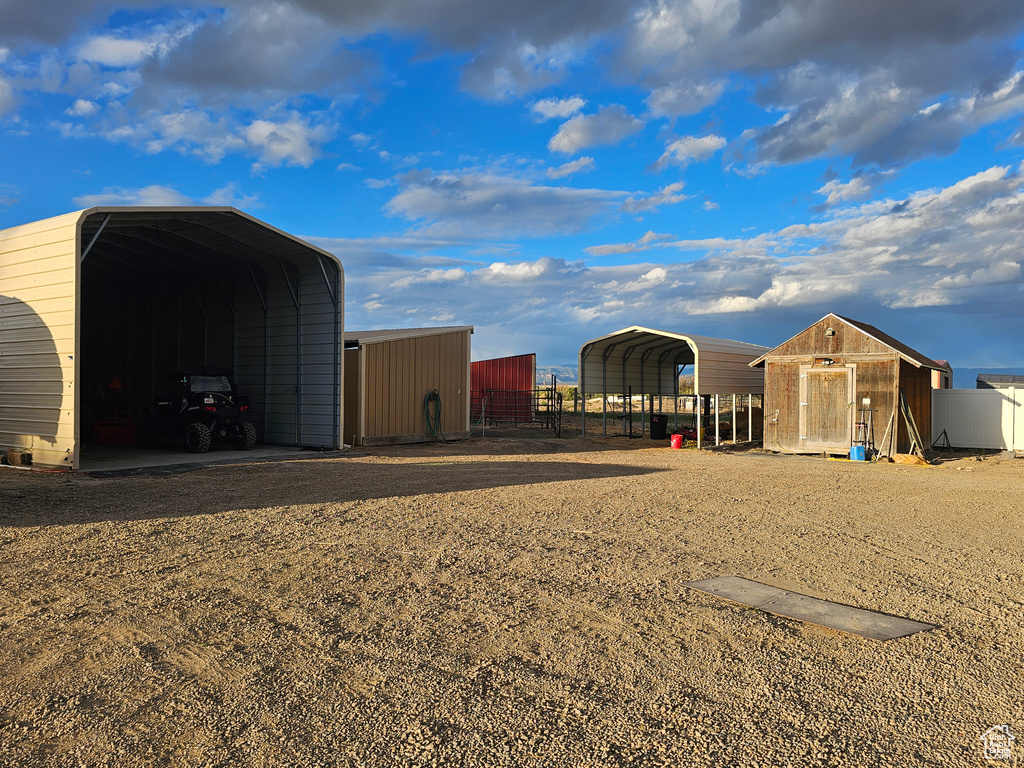 View of outbuilding with a carport and fence
