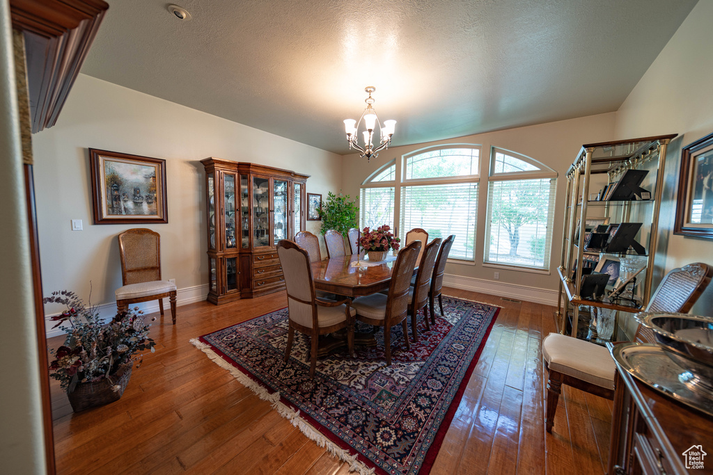Dining area with a chandelier, baseboards, and hardwood / wood-style floors