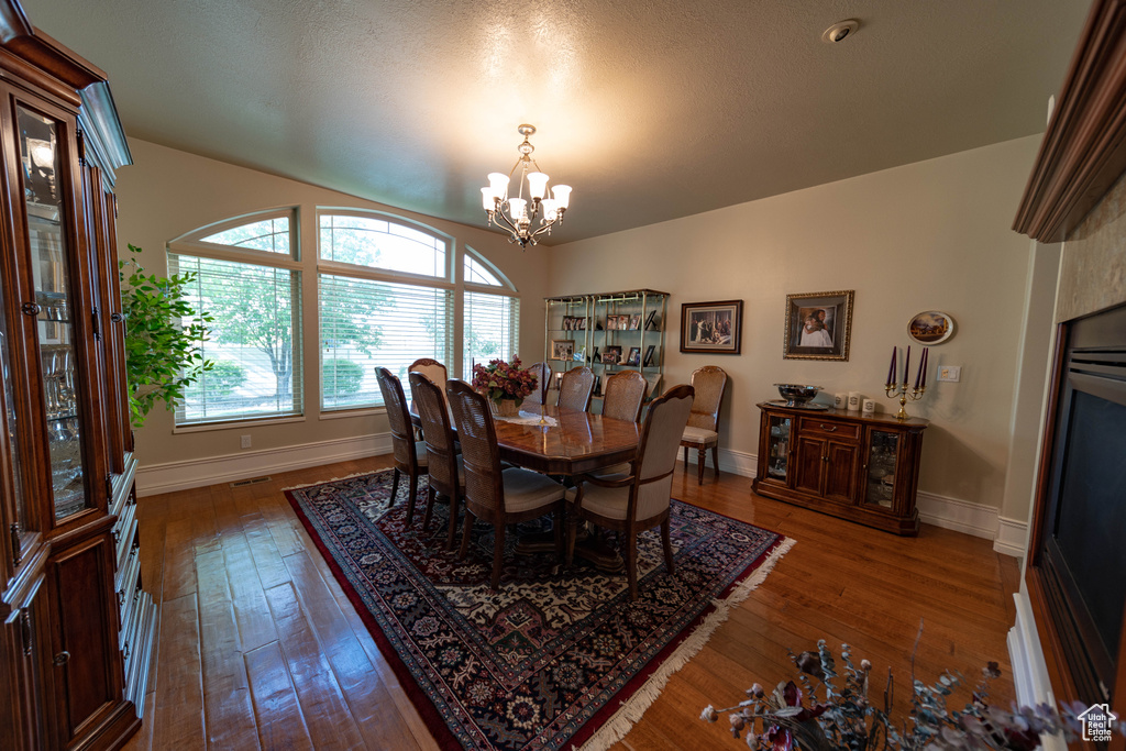 Dining room featuring a chandelier, wood-type flooring, and baseboards