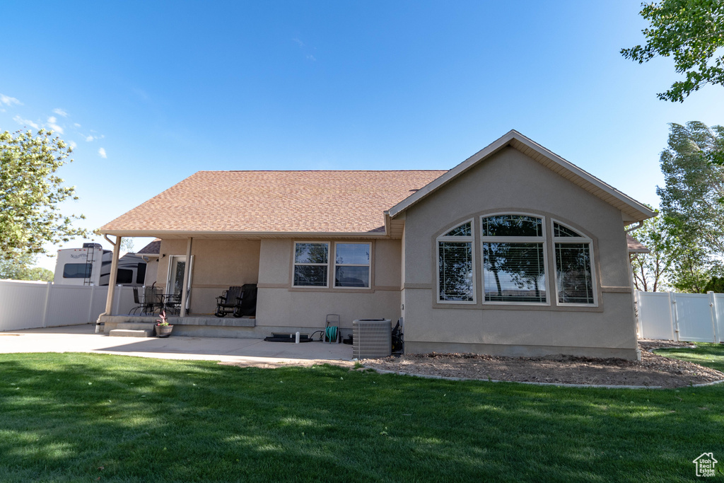 Rear view of house with central AC unit, stucco siding, and a patio area