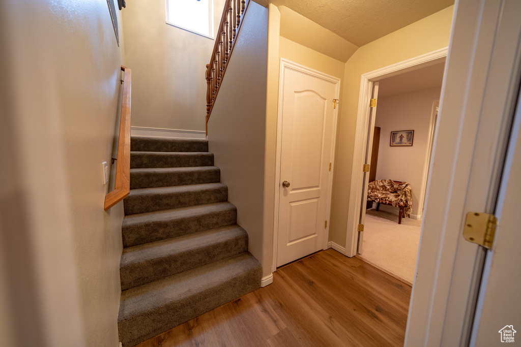 Staircase with wood finished floors and baseboards