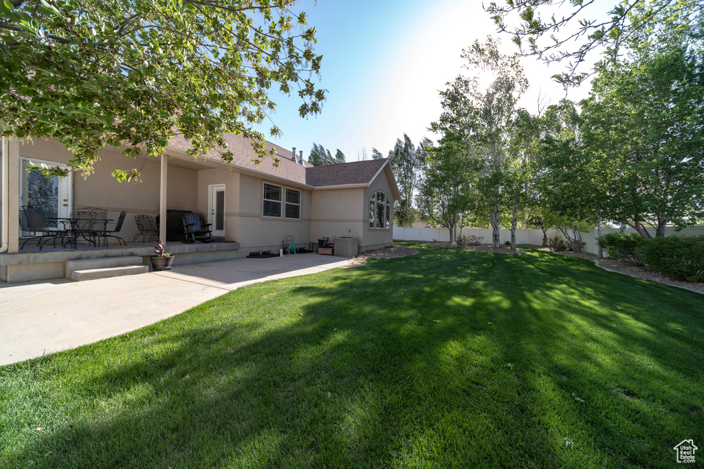 View of yard with a patio area and central air condition unit