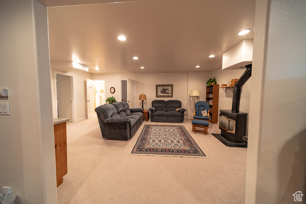 Living room with a wood stove, recessed lighting, and carpet flooring
