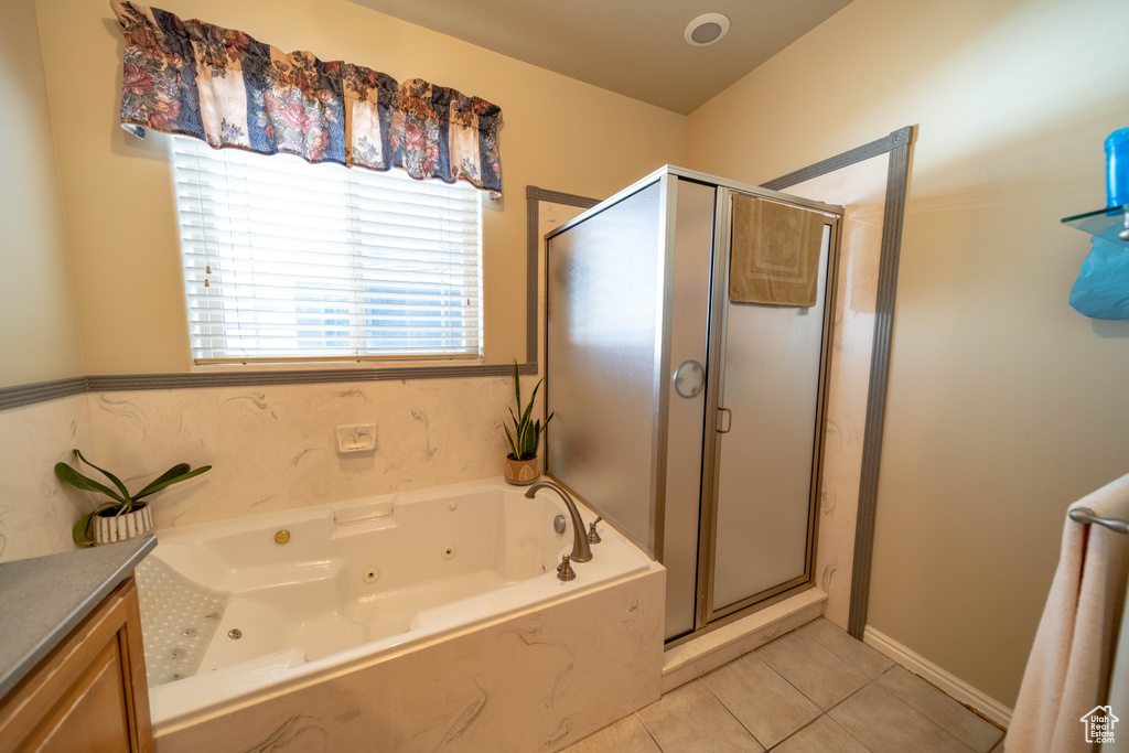 Full bath with tile patterned floors, a whirlpool tub, a shower stall, and vanity