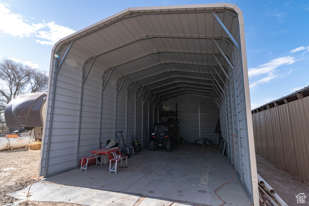View of parking with a detached carport and fence