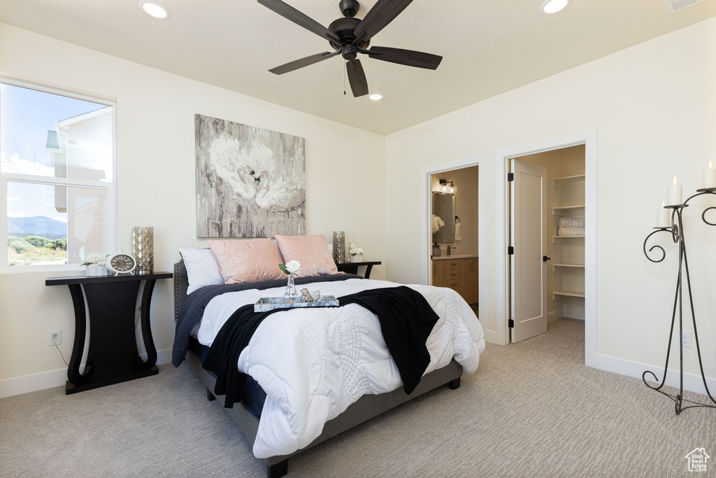 Carpeted bedroom featuring baseboards, recessed lighting, a walk in closet, ensuite bath, and ceiling fan