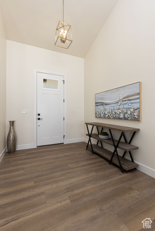 Foyer with a chandelier, wood finished floors, and baseboards