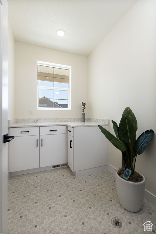 Clothes washing area featuring baseboards, light floors, and recessed lighting