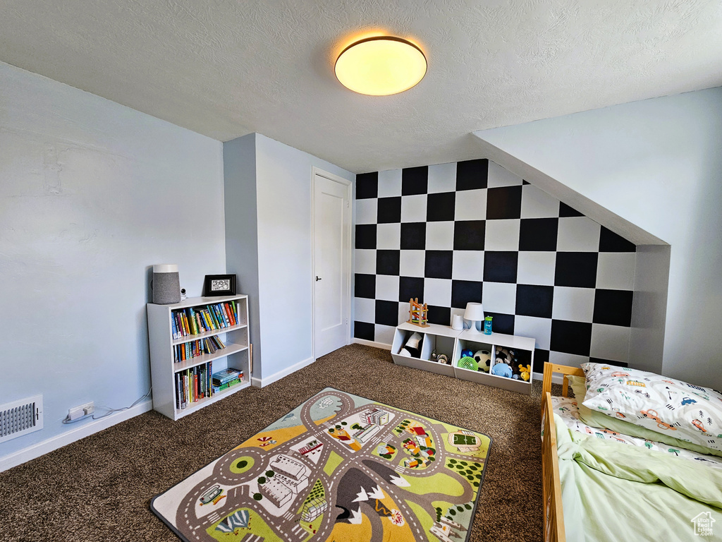 Bedroom featuring carpet floors and a textured ceiling