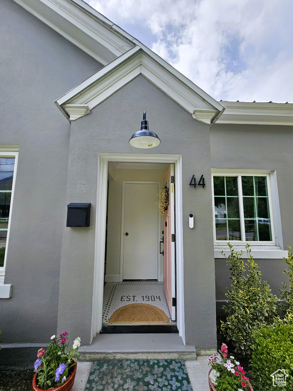 Doorway to property featuring stucco siding