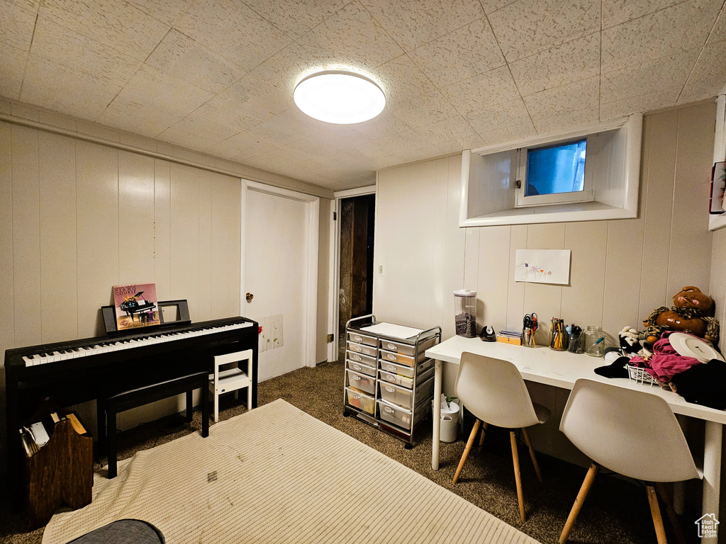 Office space featuring dark colored carpet and a decorative wall