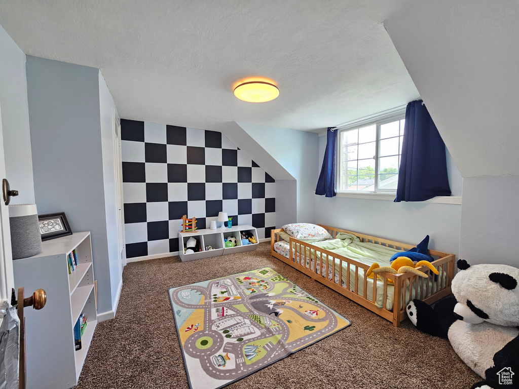 Bedroom featuring carpet and an accent wall