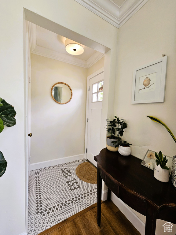 Entrance foyer with ornamental molding, dark wood finished floors, and baseboards