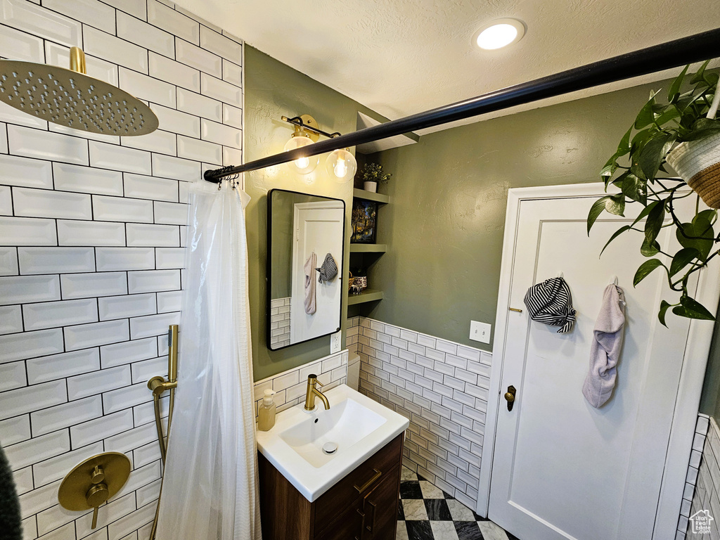 Bathroom with tile walls, a shower with curtain, vanity, wainscoting, and recessed lighting