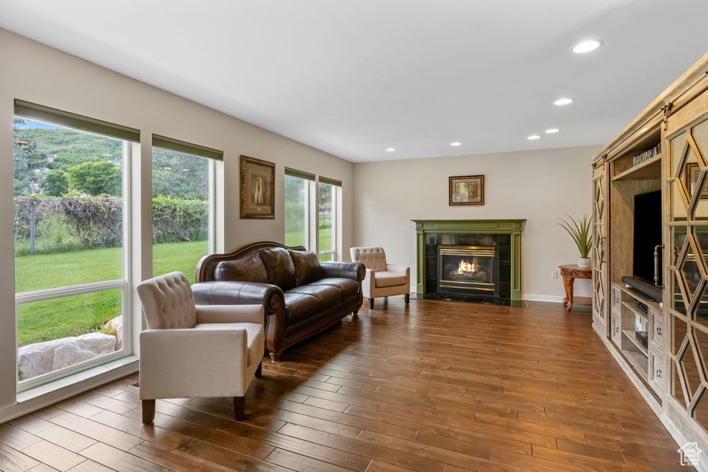 Living room featuring dark wood-type flooring, recessed lighting, and a tile fireplace