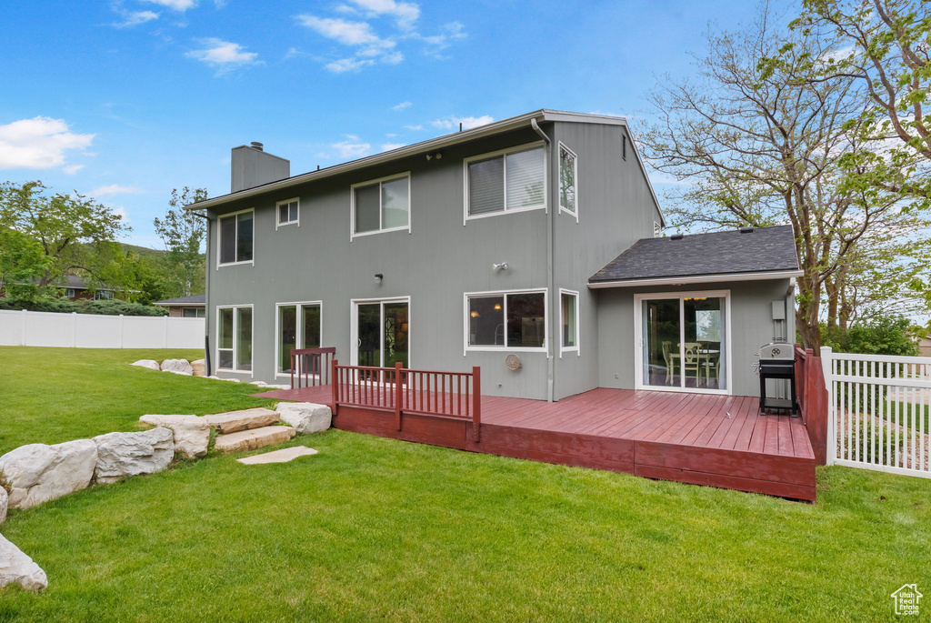 Back of house featuring a chimney and a wooden deck