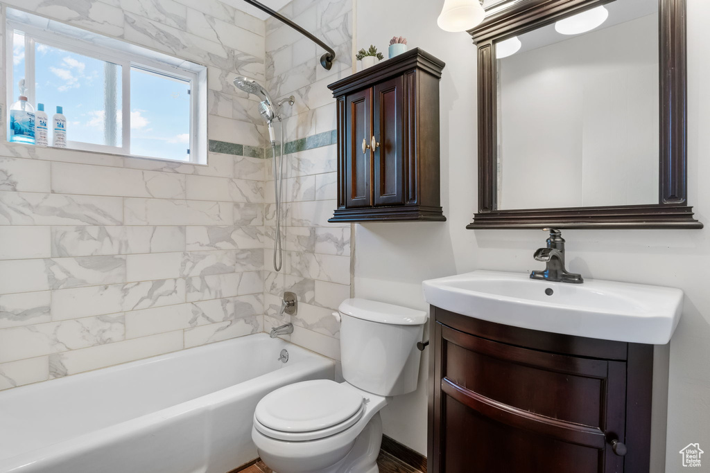 Bathroom with toilet, shower / washtub combination, and vanity