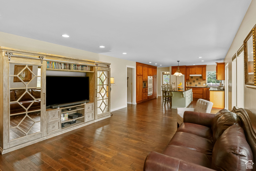 Living area with recessed lighting, dark wood-style floors, and baseboards