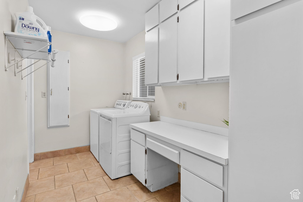 Laundry room featuring cabinet space, separate washer and dryer, an office area, baseboards, and light tile patterned flooring