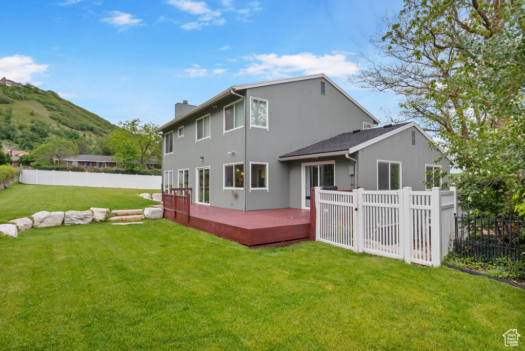 Rear view of house with a chimney and a deck with mountain view