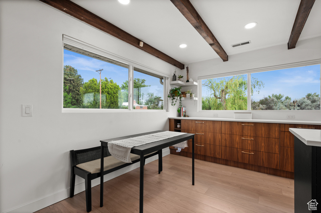 Dining area featuring beamed ceiling, light wood-style flooring, recessed lighting, and baseboards