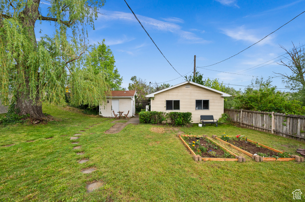 View of yard featuring a vegetable garden and an outbuilding