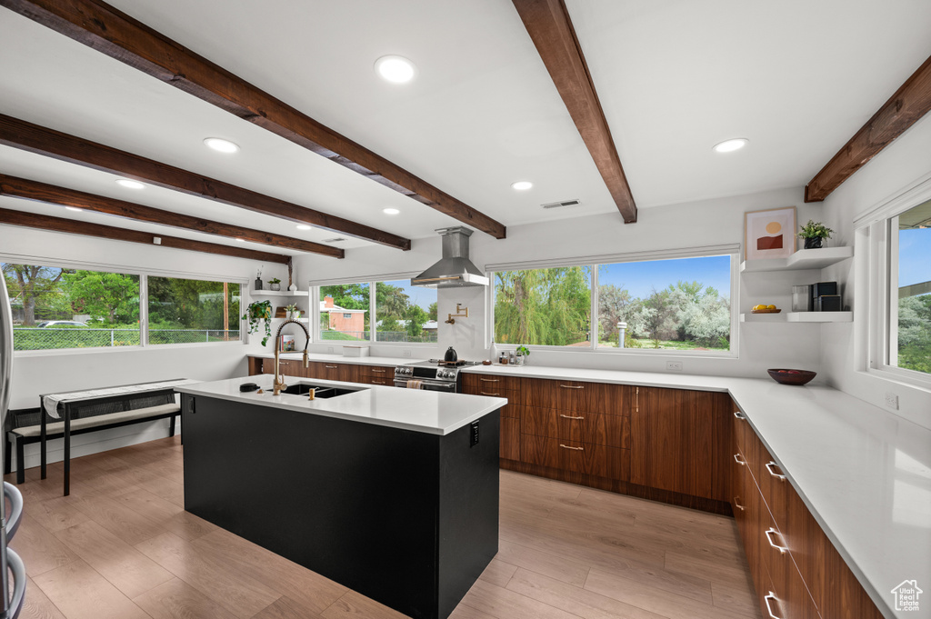 Kitchen featuring modern cabinets, a sink, exhaust hood, open shelves, and light countertops