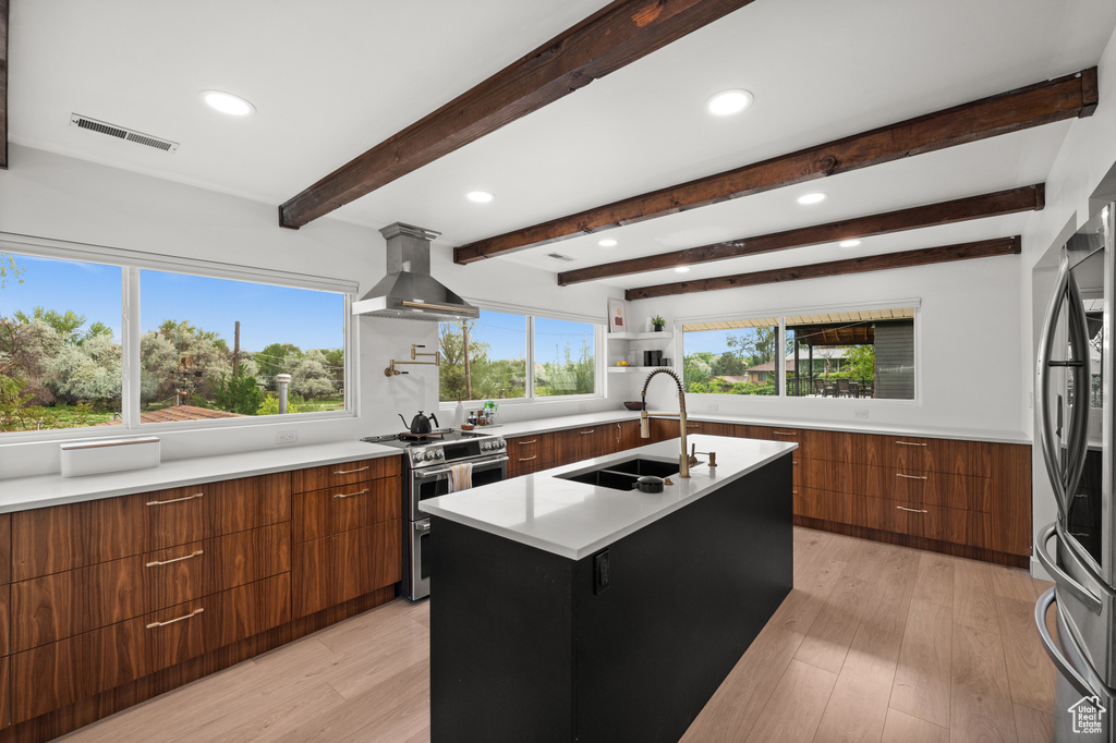 Kitchen with modern cabinets, stainless steel appliances, a sink, extractor fan, and brown cabinets
