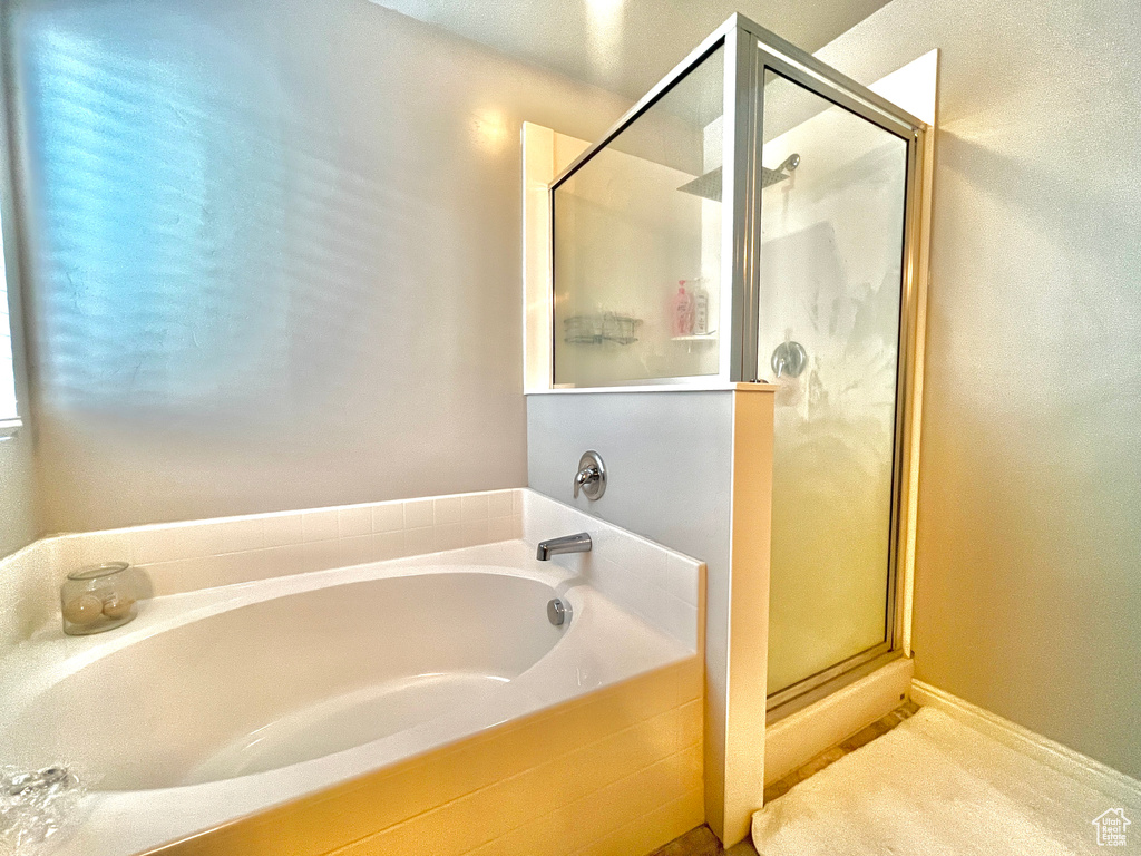 Bathroom featuring a stall shower and a garden tub
