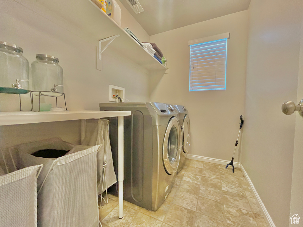 Laundry room featuring independent washer and dryer and baseboards