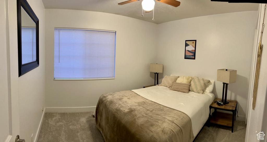Carpeted bedroom with baseboards and ceiling fan