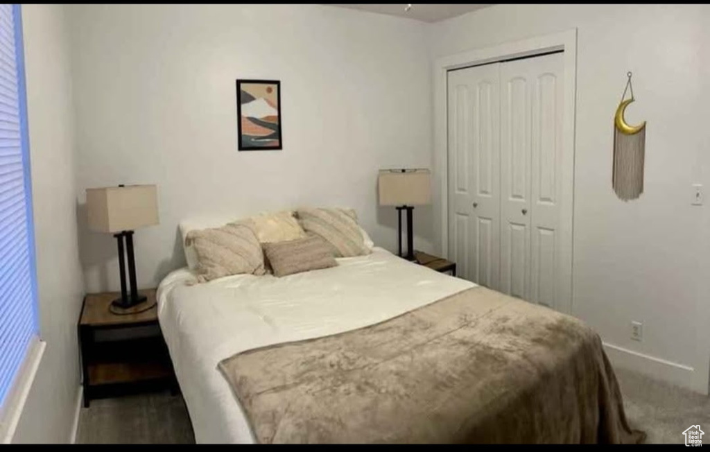 Carpeted bedroom featuring a closet and baseboards