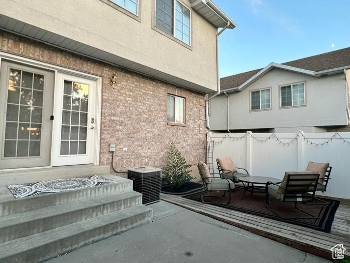 Back of house with fence, central air condition unit, a patio area, and stucco siding