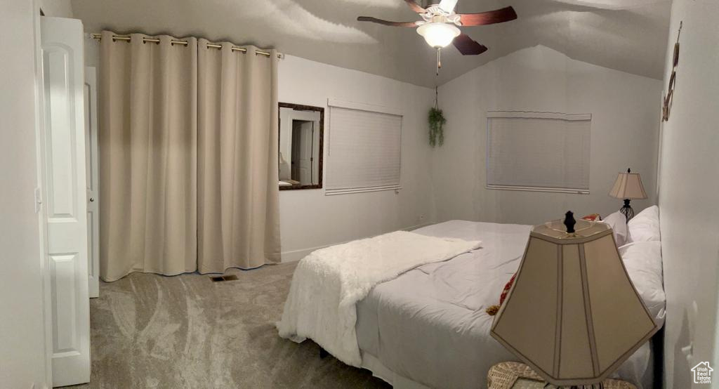 Bedroom featuring carpet, lofted ceiling, and a ceiling fan
