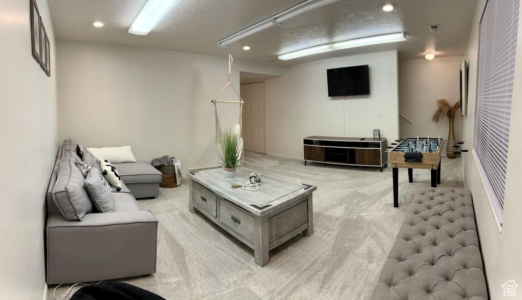 Living room featuring light colored carpet, recessed lighting, and a textured ceiling
