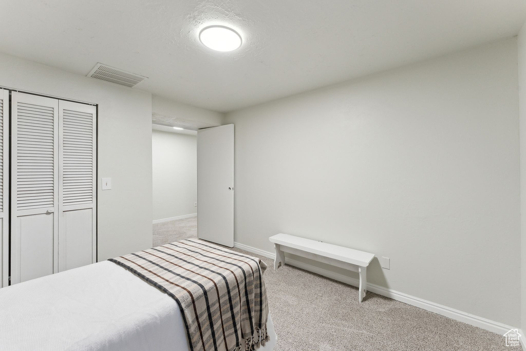 Bedroom with carpet flooring, baseboards, and a closet
