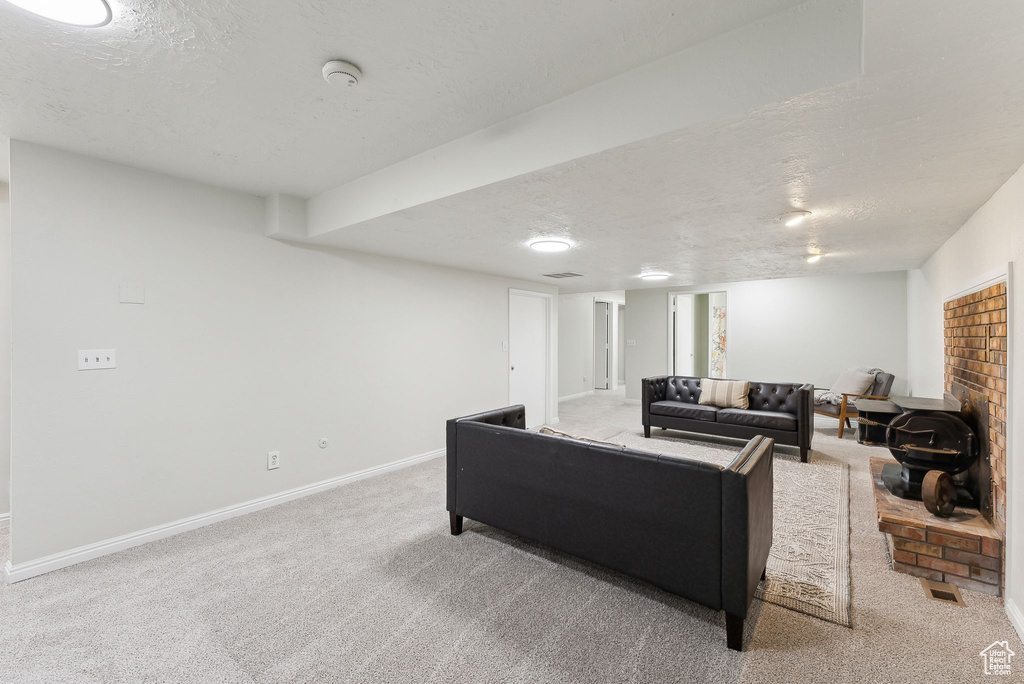 Carpeted living area featuring a textured ceiling and baseboards