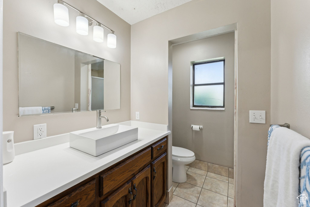 Full bath featuring toilet, vanity, and tile patterned floors