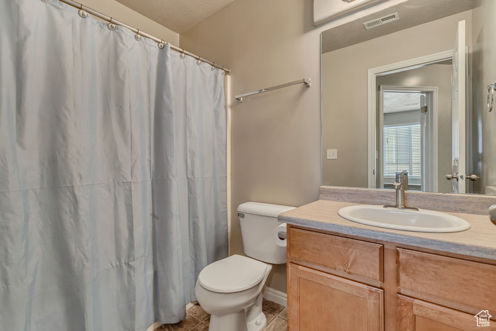 Full bathroom featuring vanity, toilet, tile patterned flooring, baseboards, and a shower with curtain