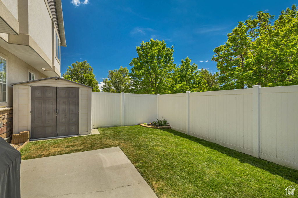 View of yard featuring a patio area, a storage shed, and an outdoor structure
