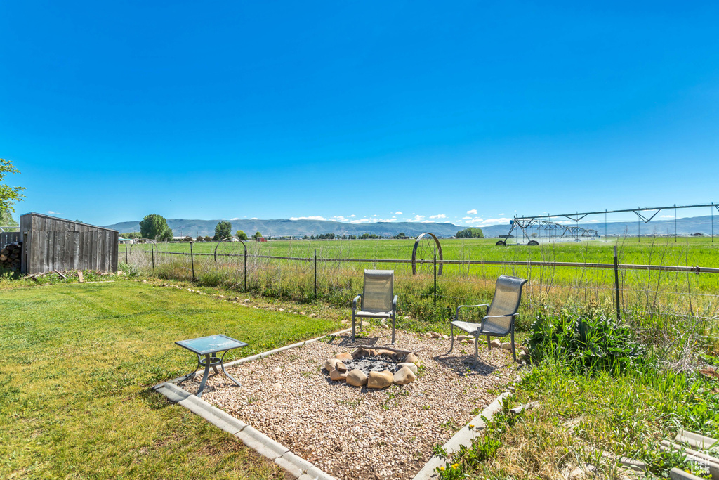 View of yard featuring a fire pit, a mountain view, and a view of countryside
