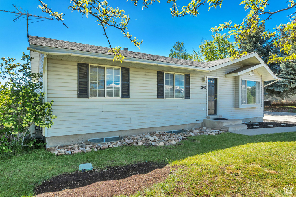 Ranch-style home featuring a front lawn