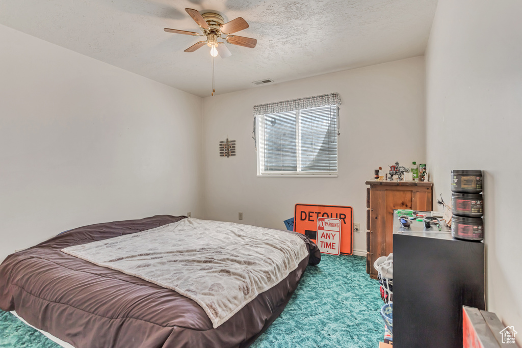 Bedroom featuring dark carpet, a textured ceiling, and a ceiling fan