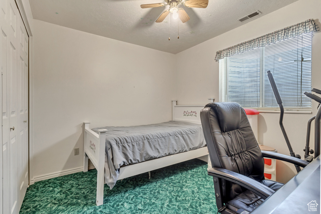 Bedroom with carpet floors, ceiling fan, baseboards, a textured ceiling, and a desk