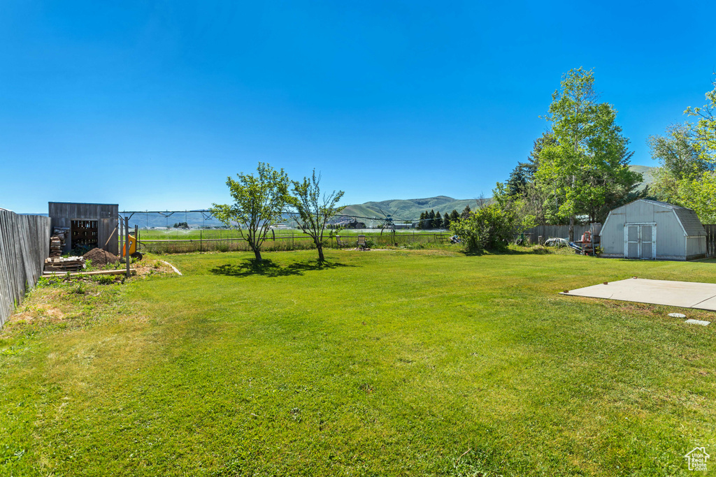View of yard with a shed, an outbuilding, and a mountain view