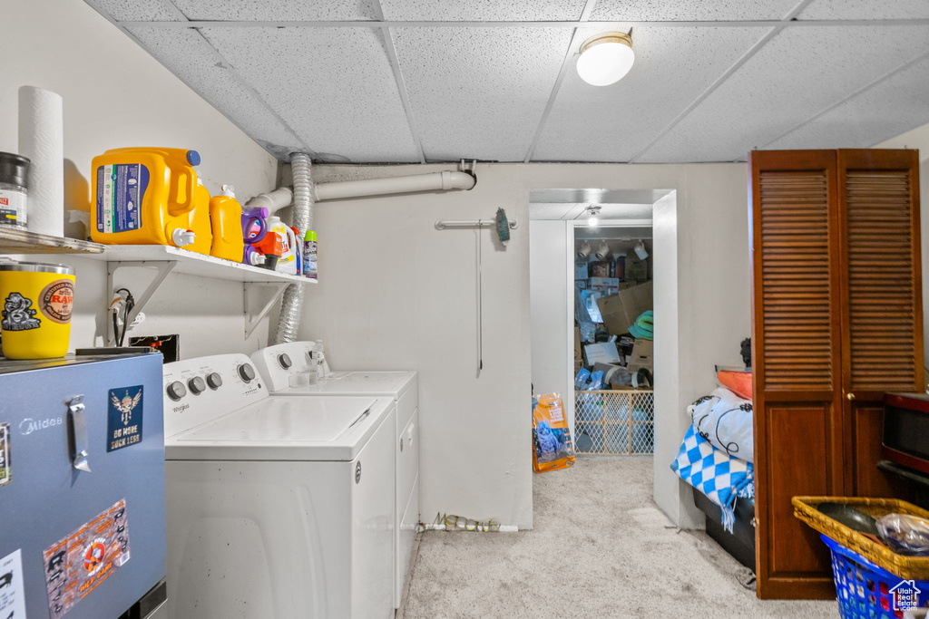 Washroom featuring water heater, carpet floors, and washing machine and clothes dryer