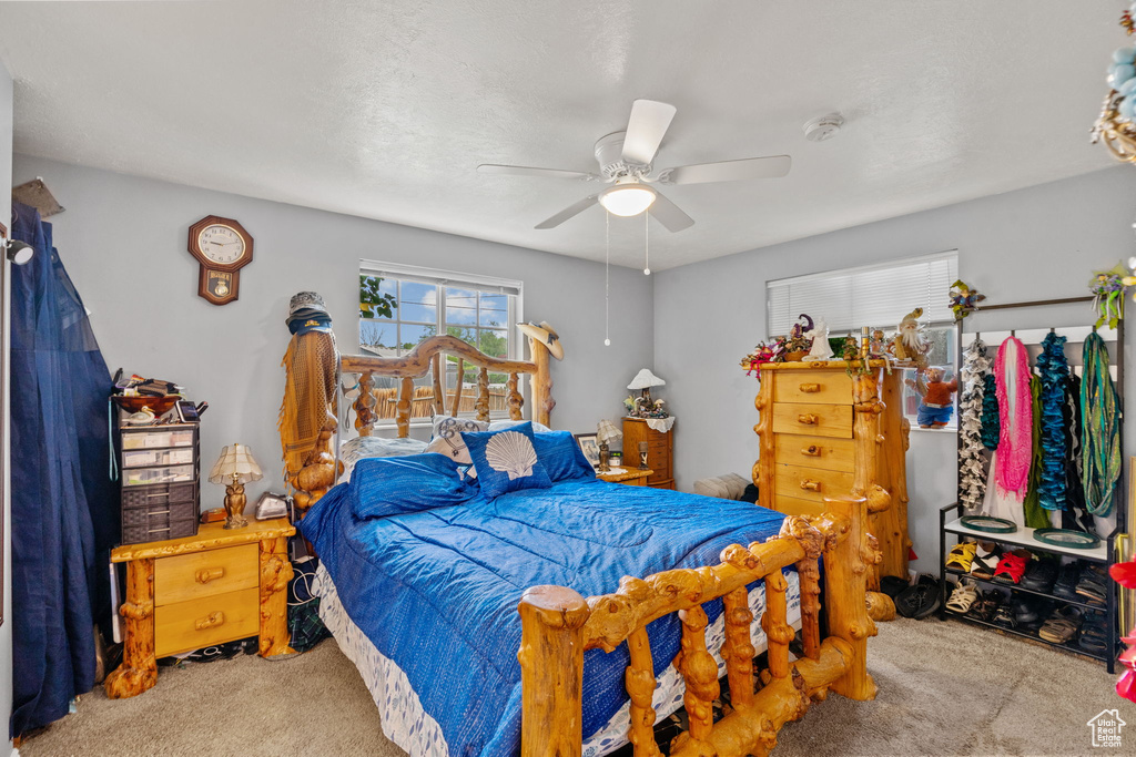 Carpeted bedroom featuring a ceiling fan